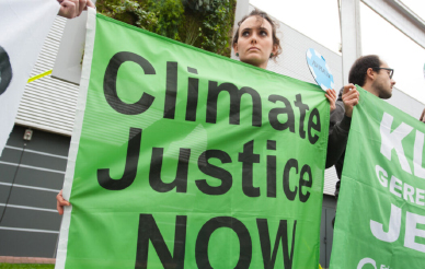 Activist holding a green sign for climate justice